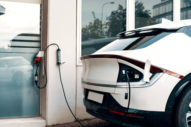 A Mode 2 portable EV charger connected between a wall power point and a car